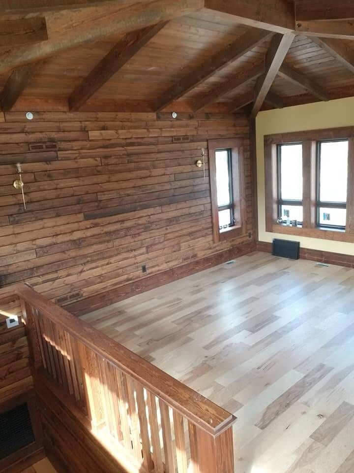 An empty room with hardwood floors and wooden walls