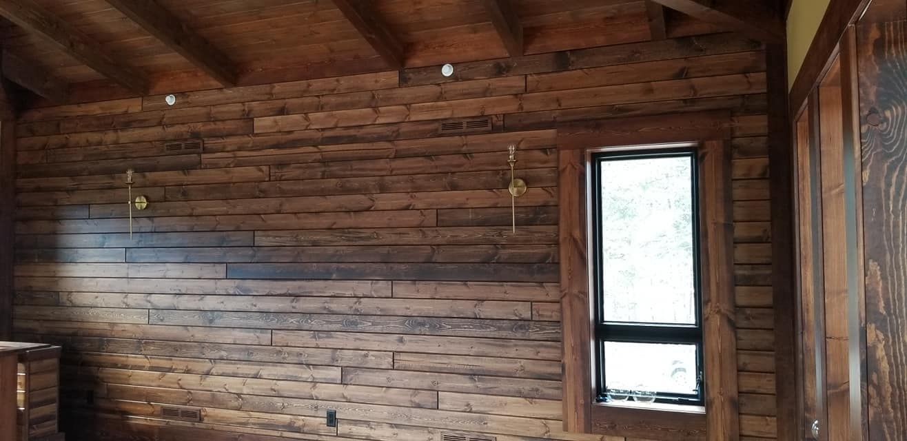 A room with a wooden wall and a window.