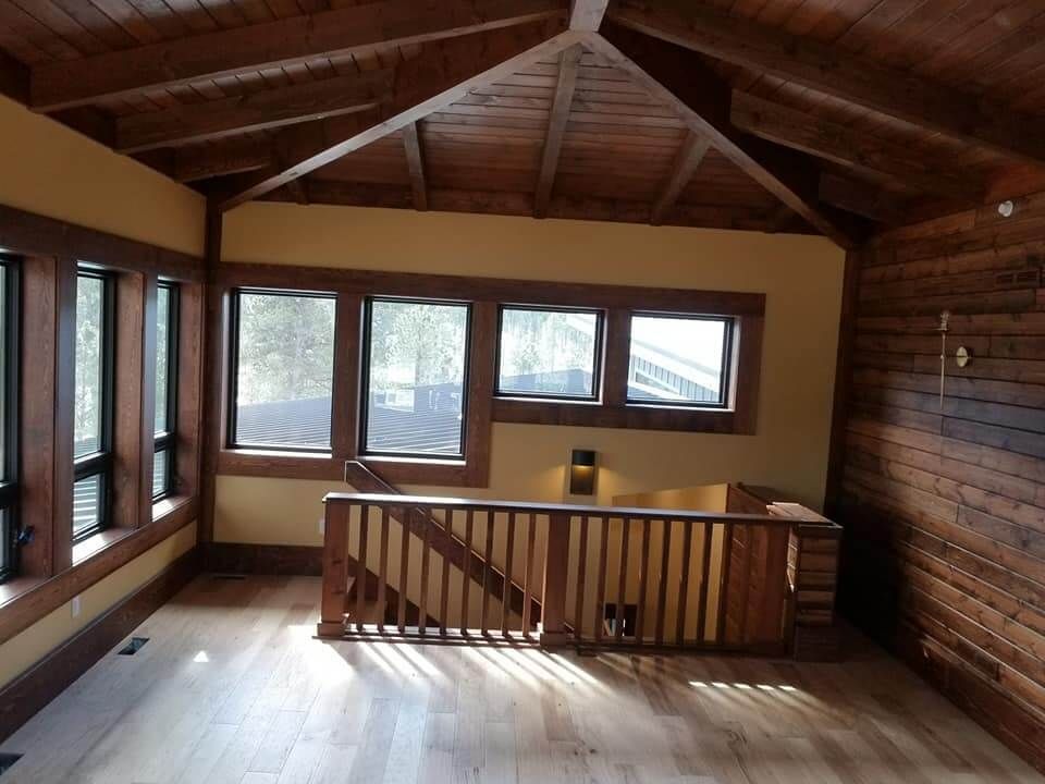 An empty room with a staircase and lots of windows
