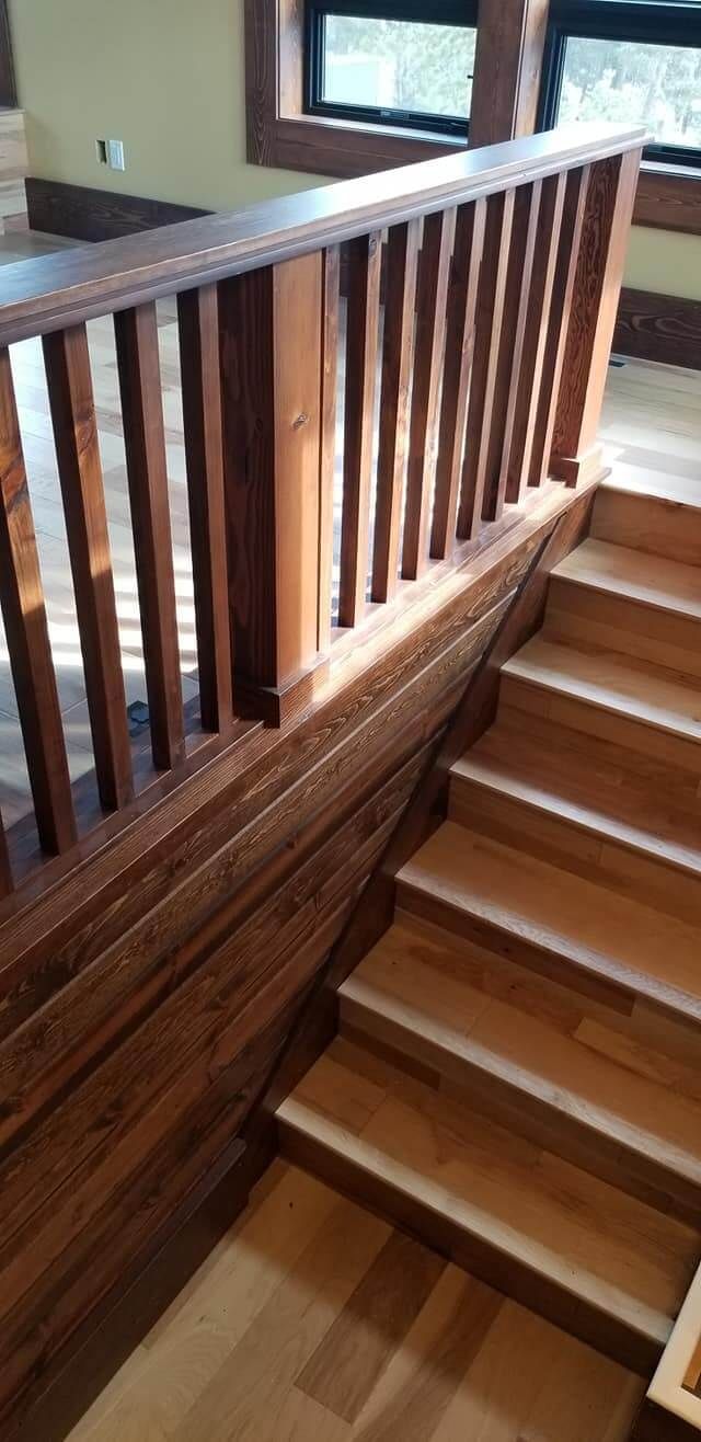 A wooden staircase with a wooden railing in a house.