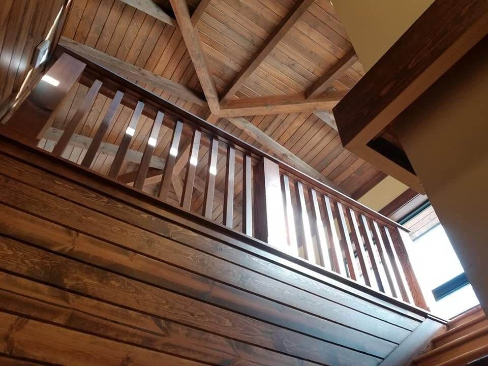 Looking up at a wooden staircase with a wooden railing