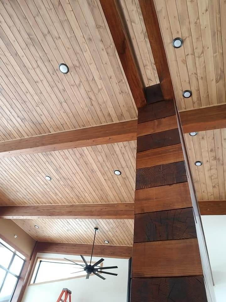 A room with a wooden ceiling and a ceiling fan