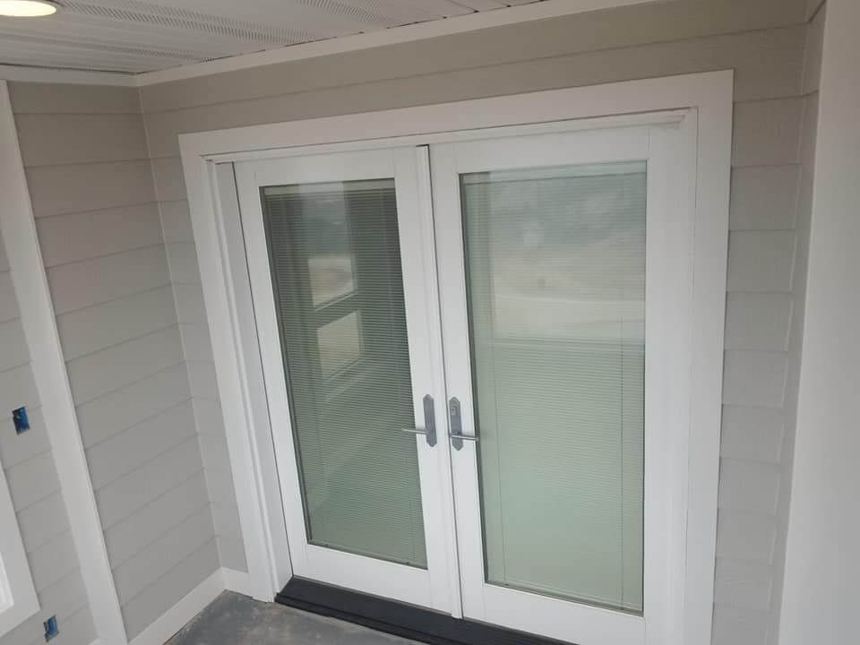 A pair of white sliding glass doors on a porch.