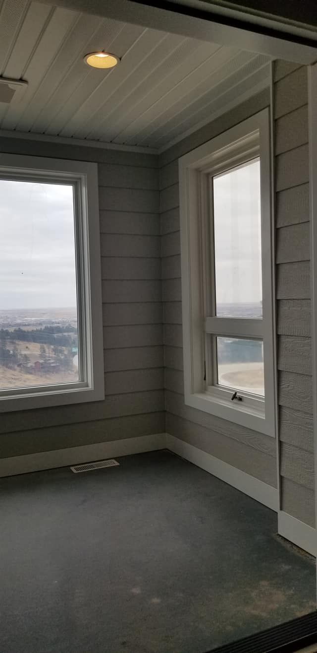 A room with a lot of windows and a view of the ocean.