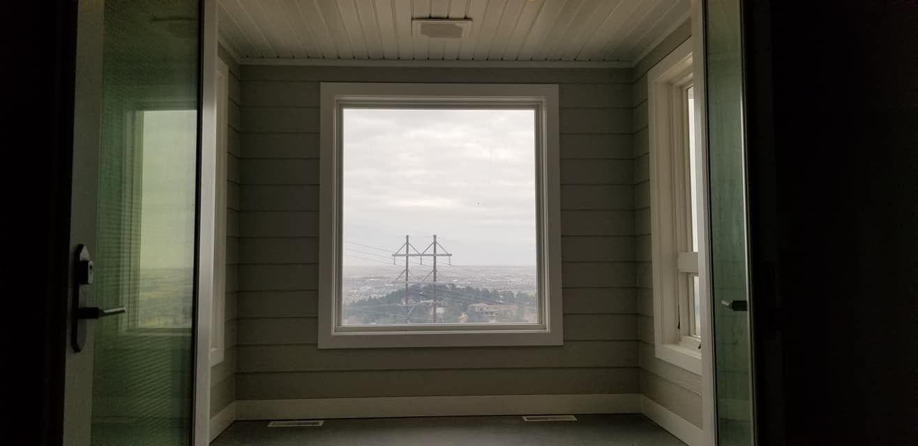 A room with a large window and a view of a city.