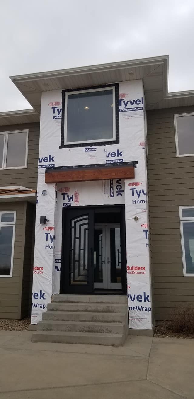A house is being built with a lot of windows and a door.