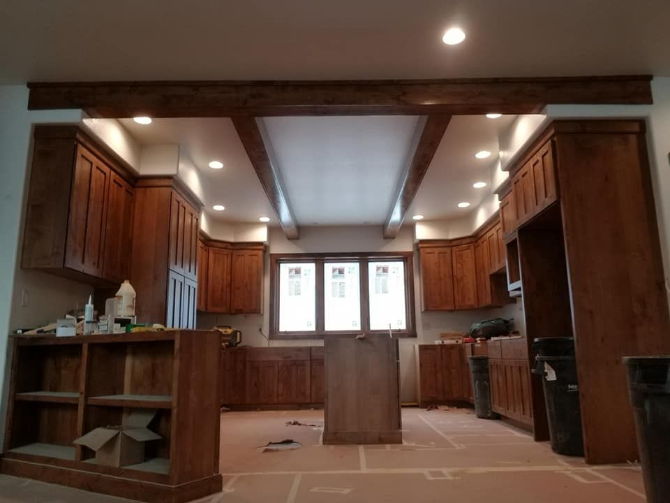 A kitchen with wooden cabinets and a large window