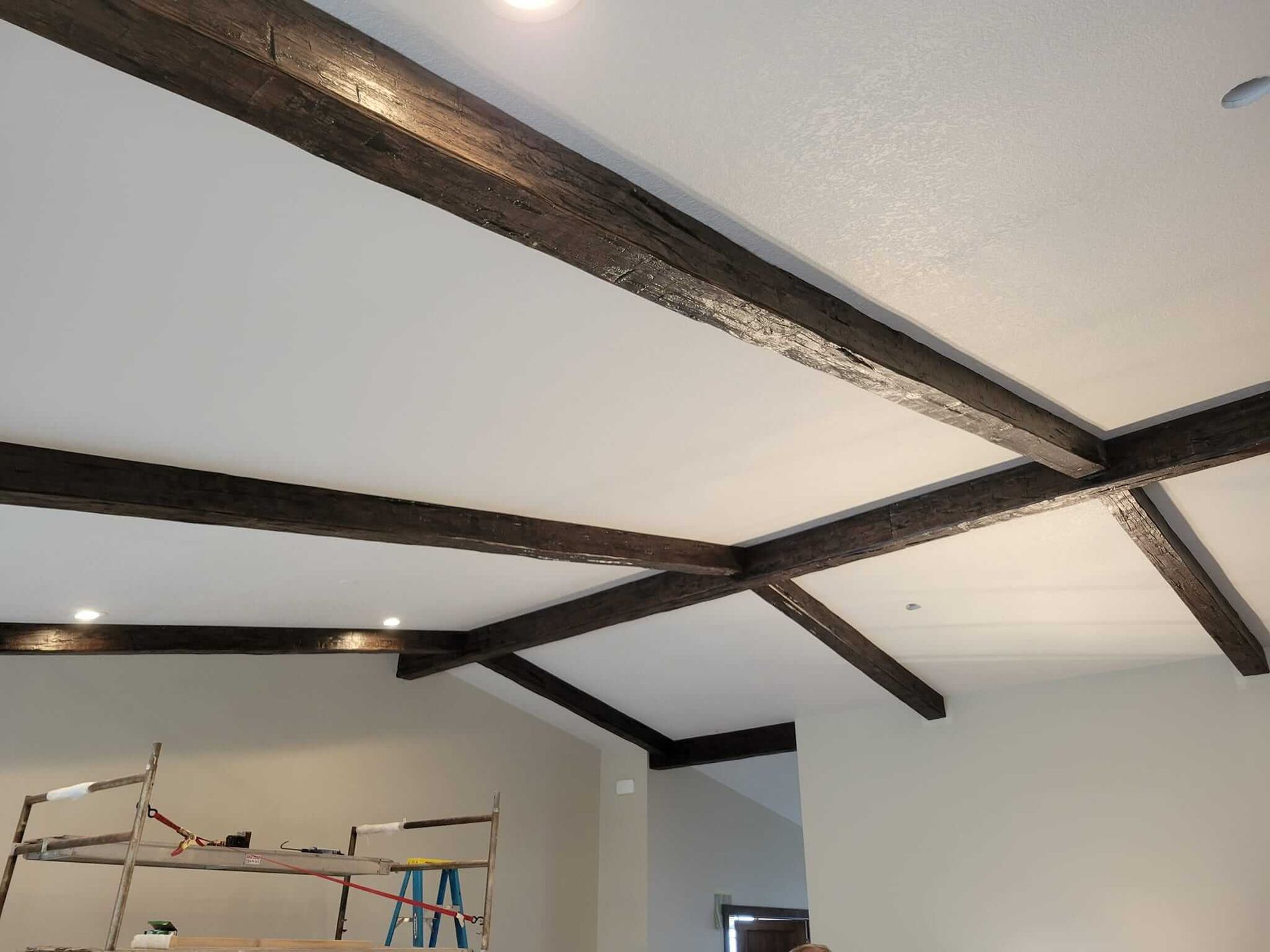 A room with a white ceiling and wooden beams