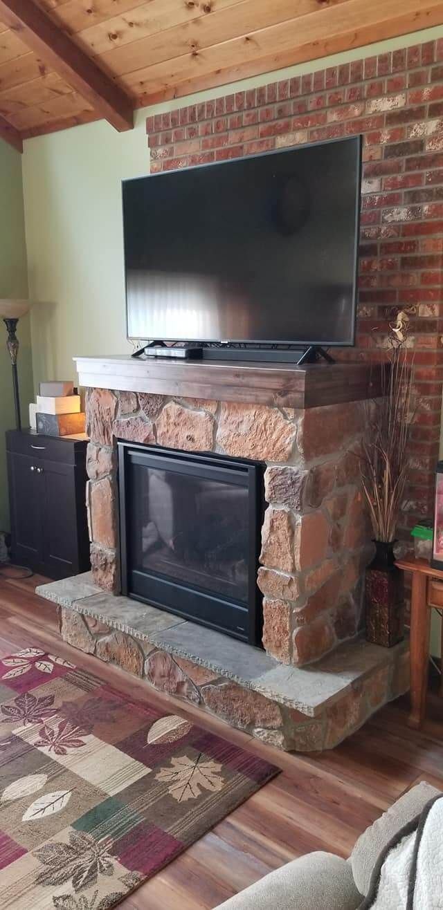 A living room with a fireplace and a flat screen tv.