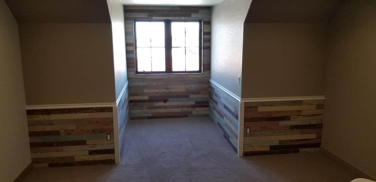 An empty room with a wooden wall and a window.
