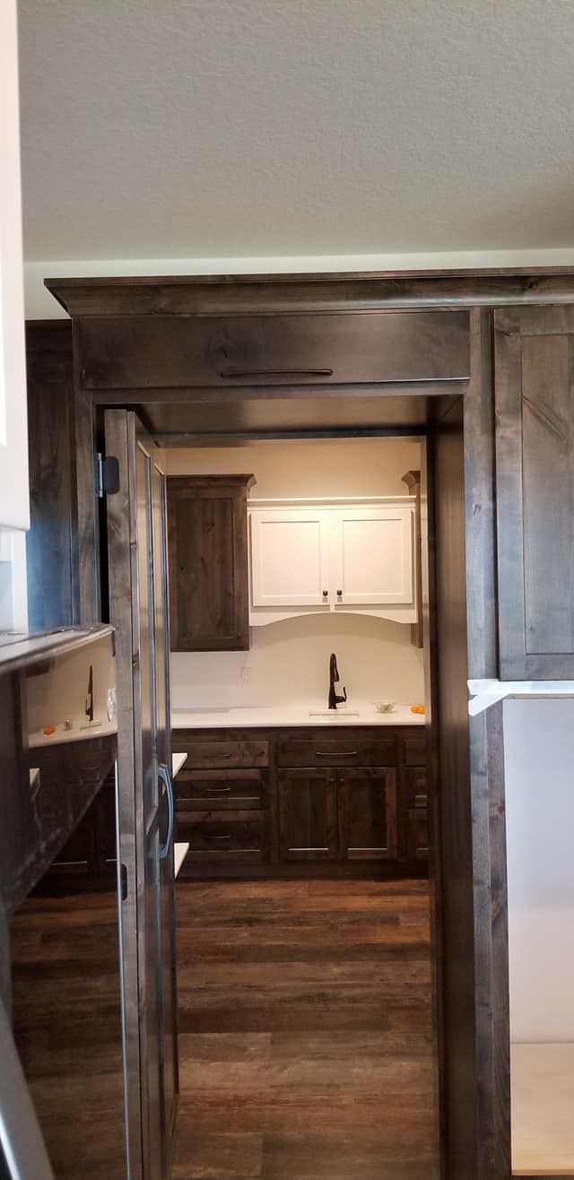 A kitchen with a sink , cabinets , and hardwood floors.