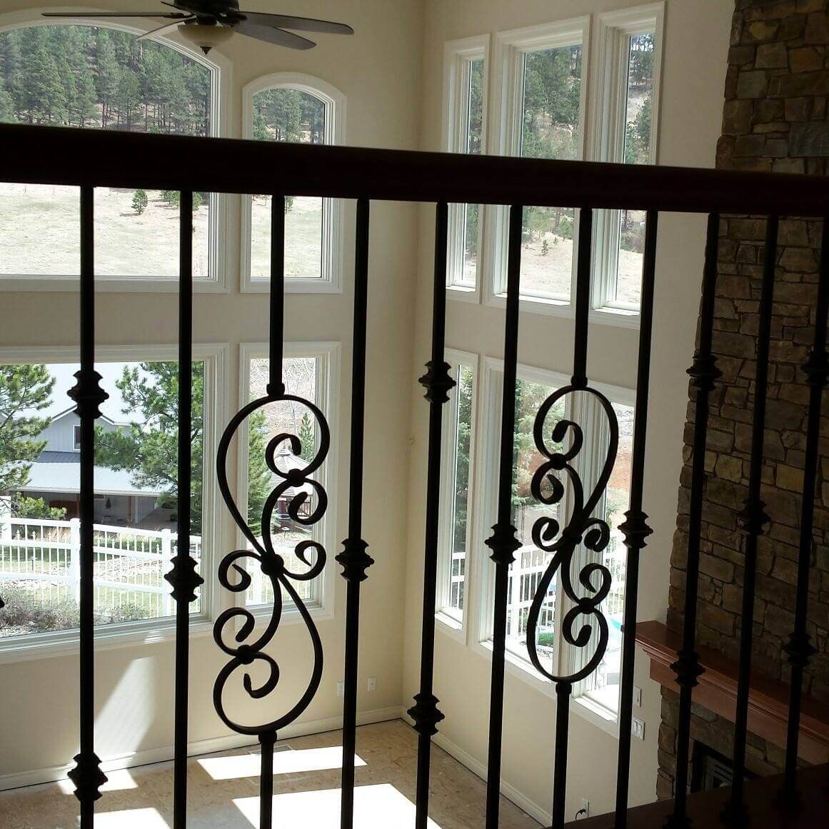 A room with lots of windows and a wrought iron railing
