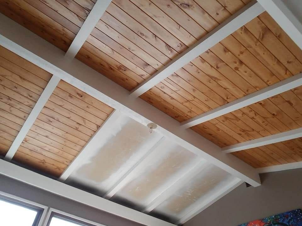 A wooden ceiling with white beams in a room