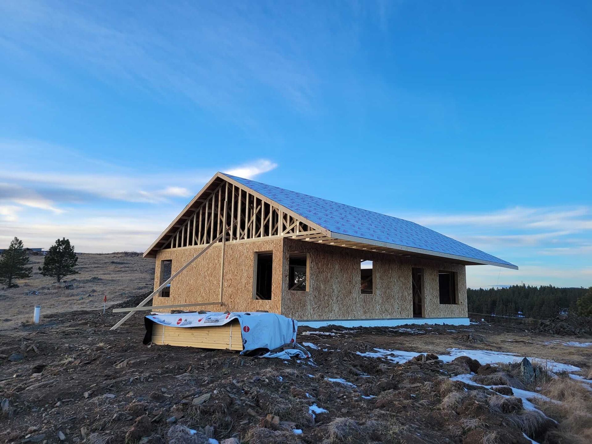 A house is being built in the middle of a dirt field.