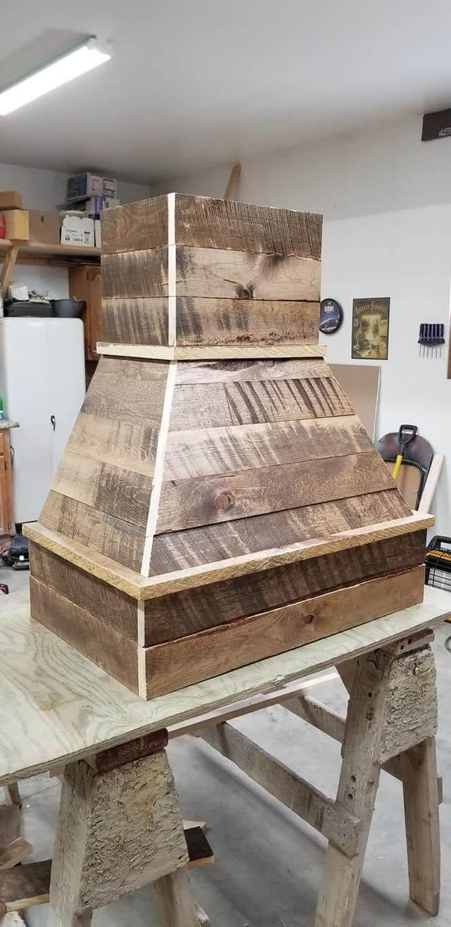 A wooden pyramid is sitting on top of a wooden table.
