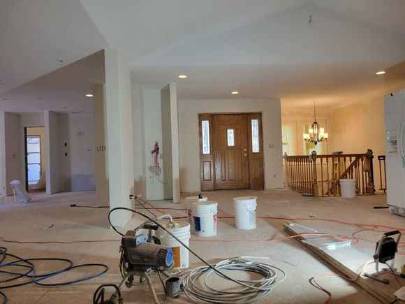 A large room is being painted in a house.