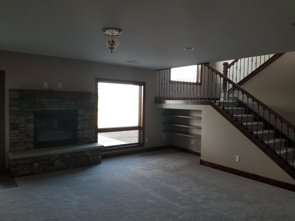 An empty living room with a fireplace and stairs
