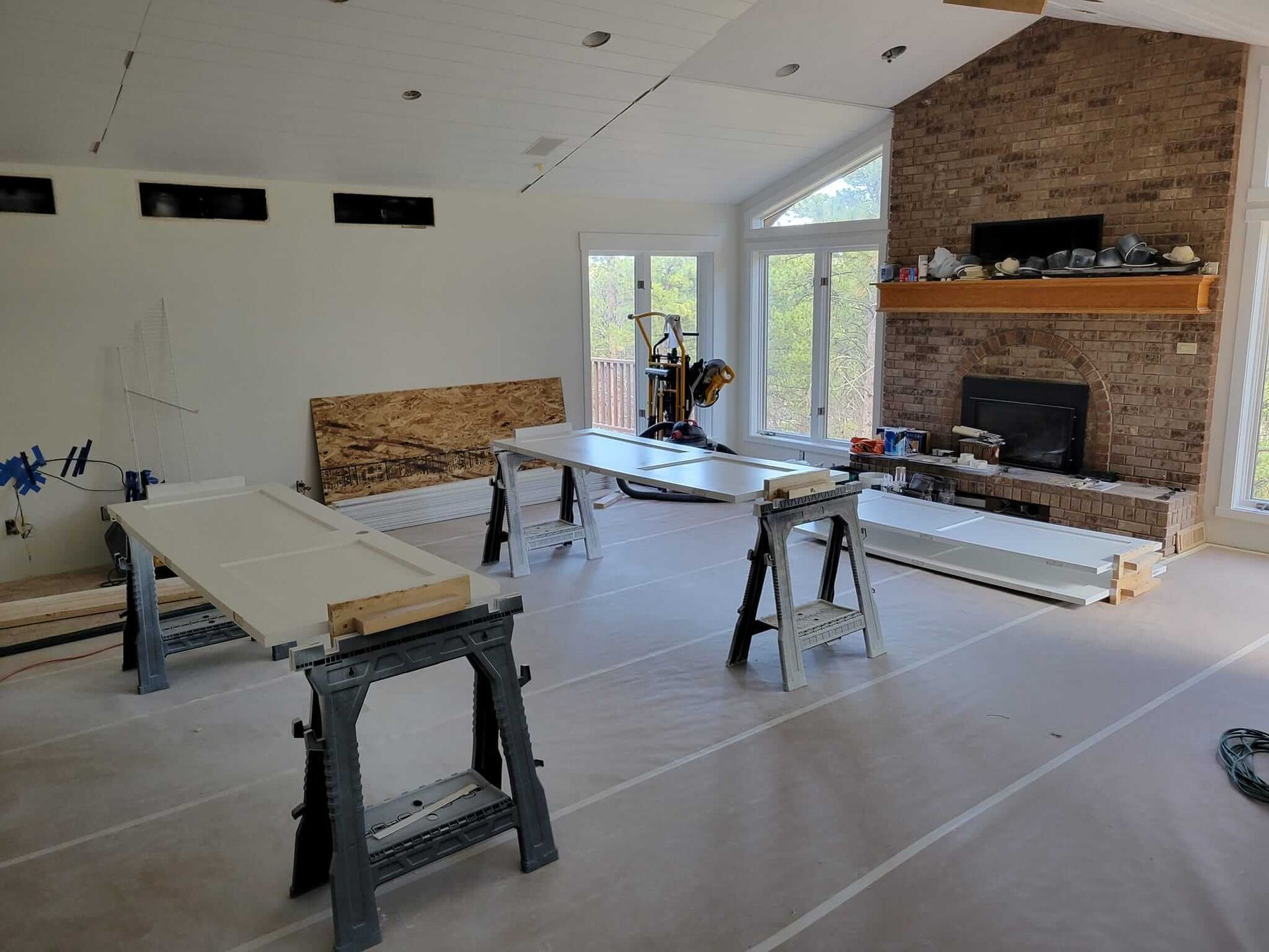 A living room is being remodeled with a fireplace and a brick wall.