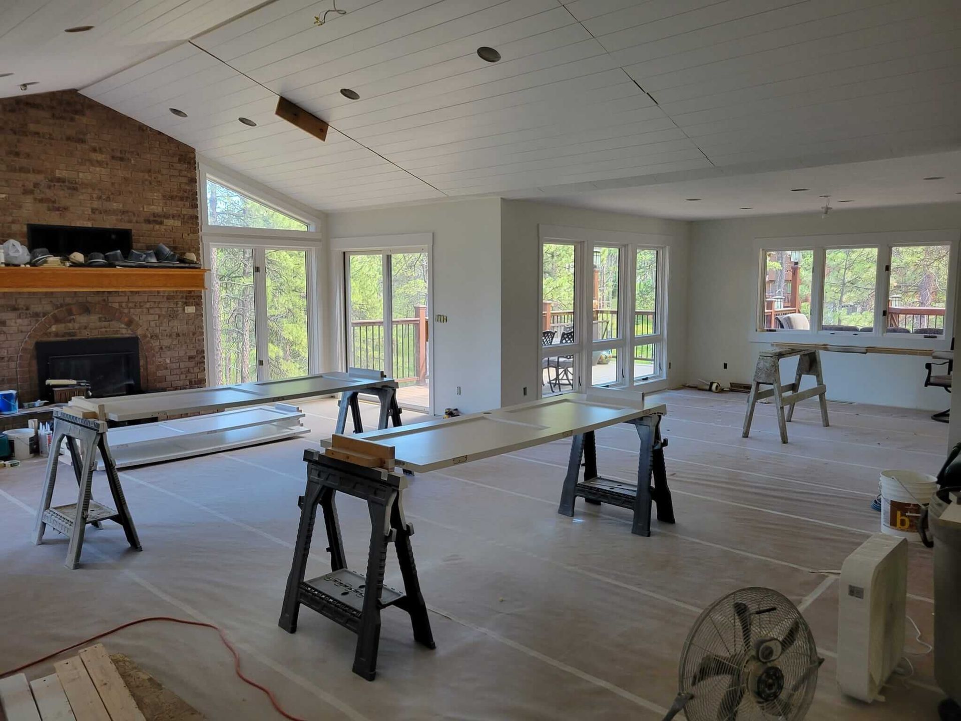 A large room with a lot of windows and a fan.