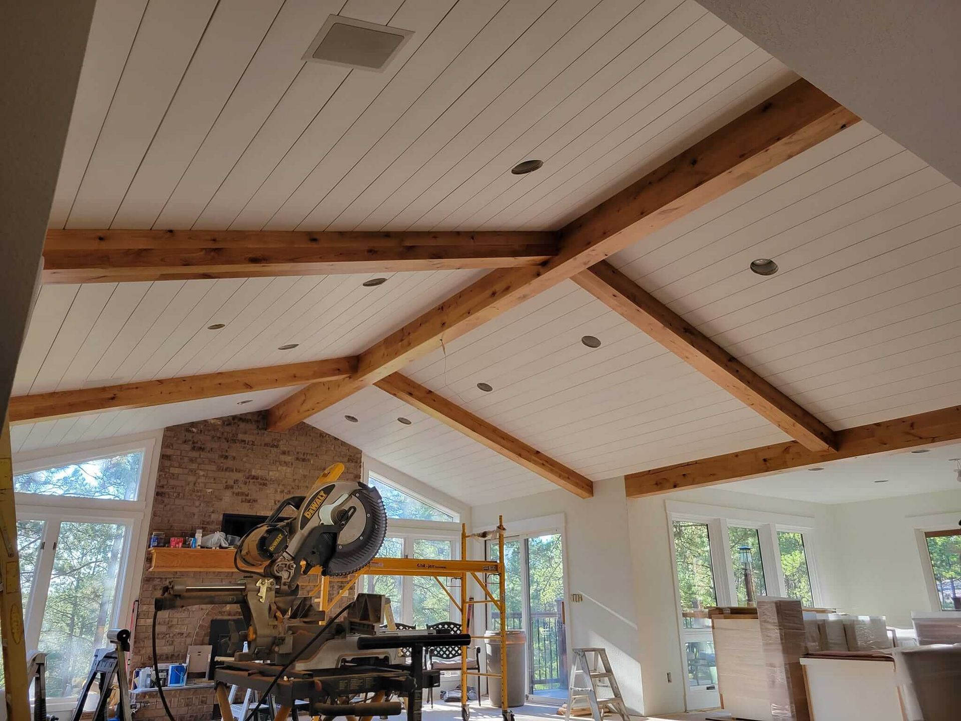 A large room with a lot of windows and wooden beams