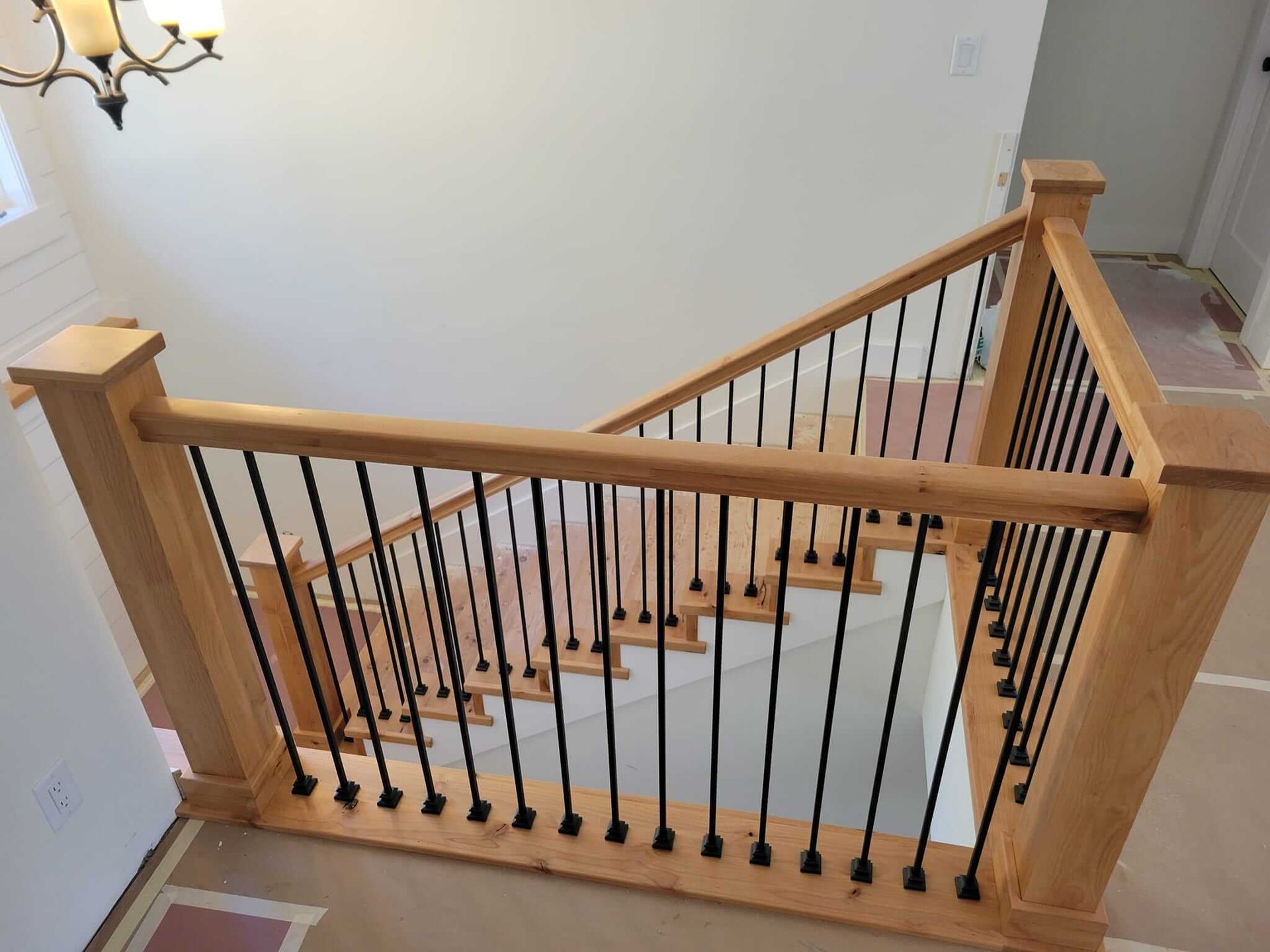 A wooden staircase with a black railing in a house
