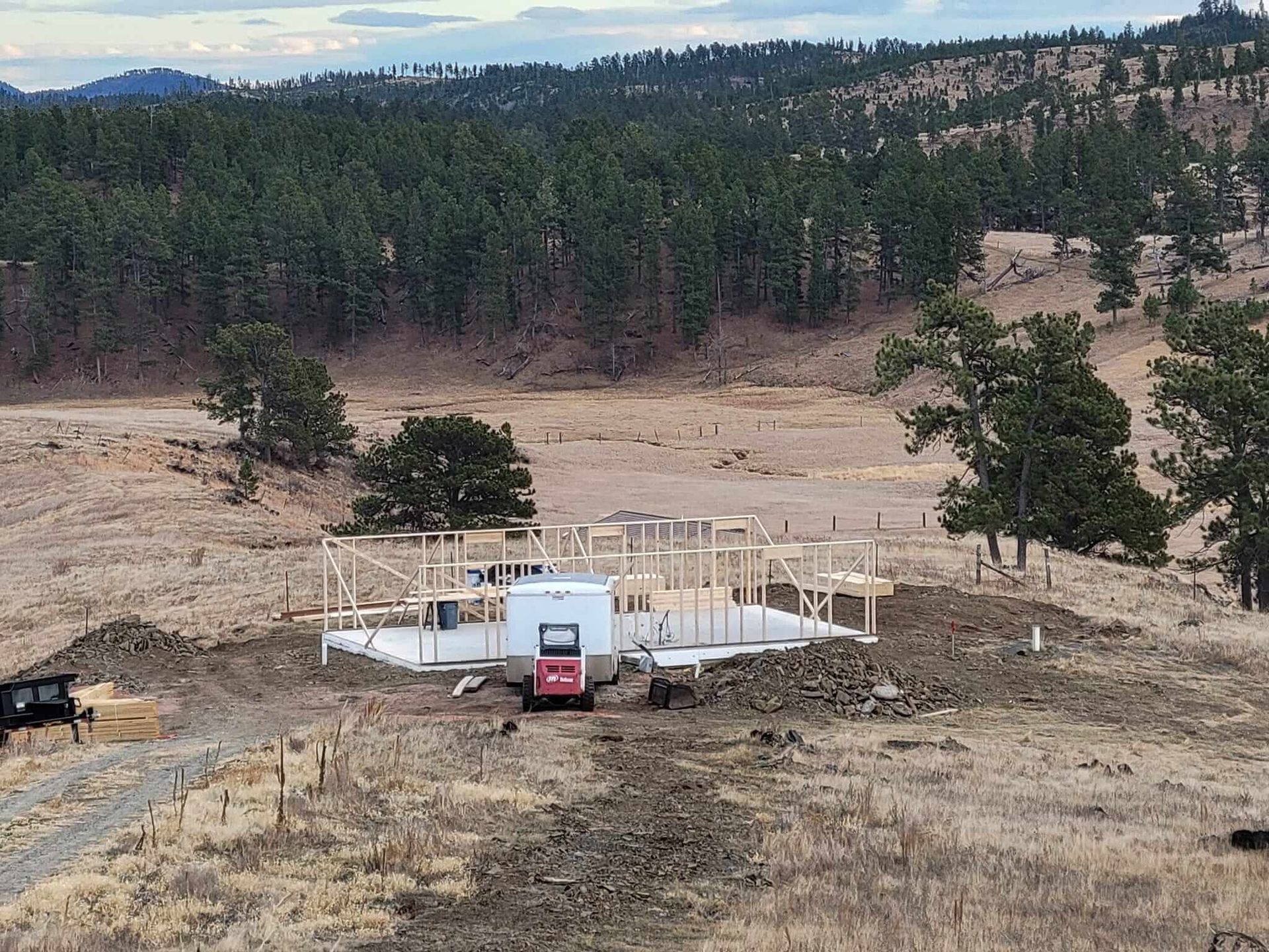 A house is being built in the middle of a dry grassy field.