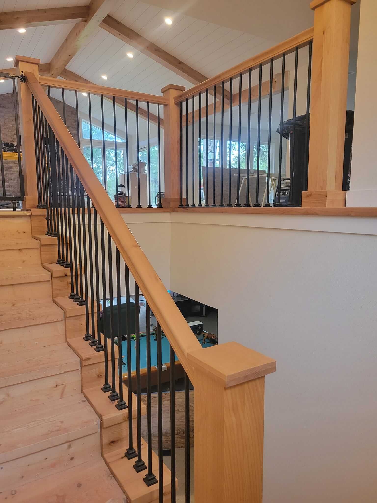 A wooden staircase with a metal railing in a house.