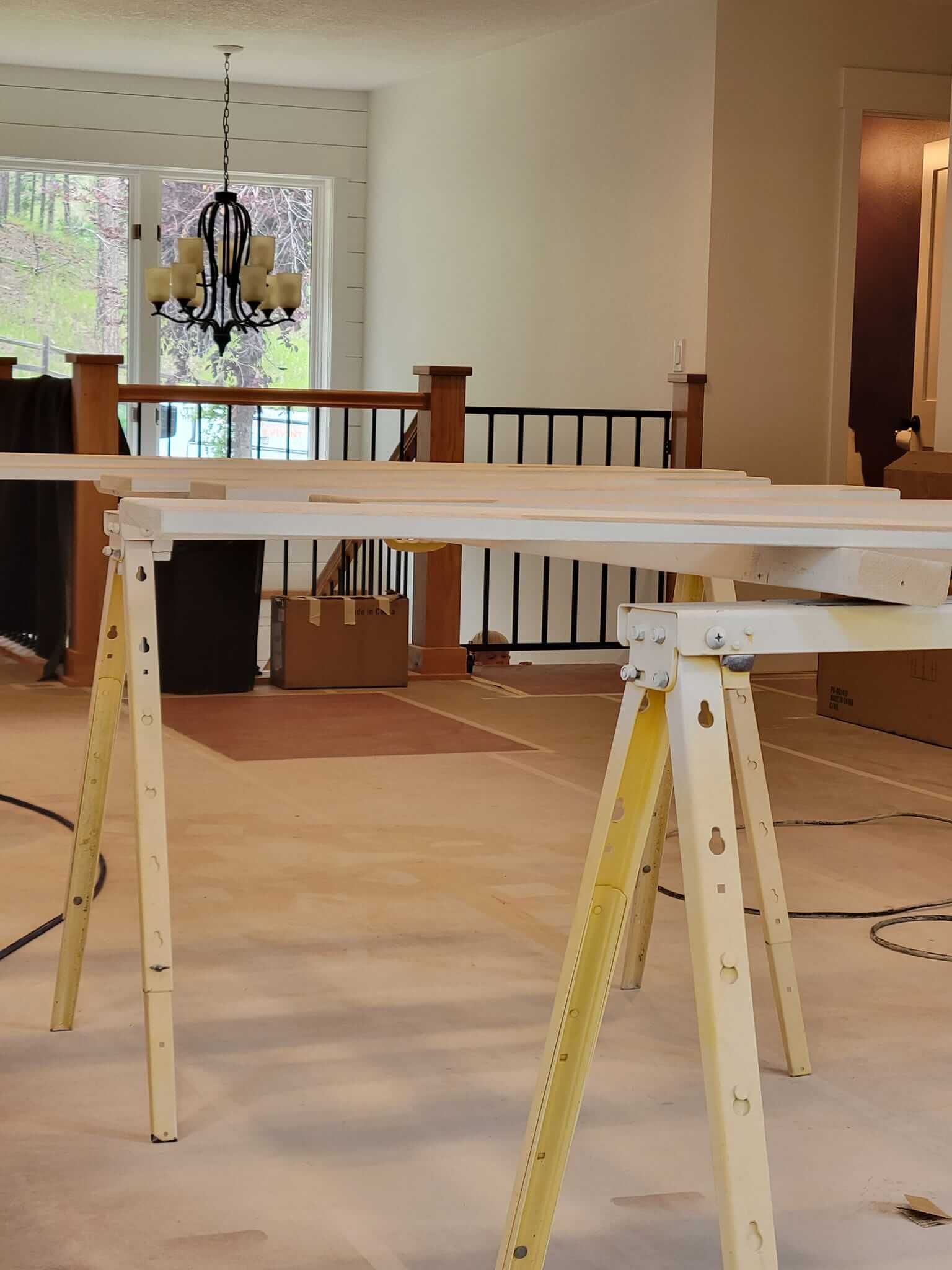 A wooden table in a room with a chandelier hanging from the ceiling