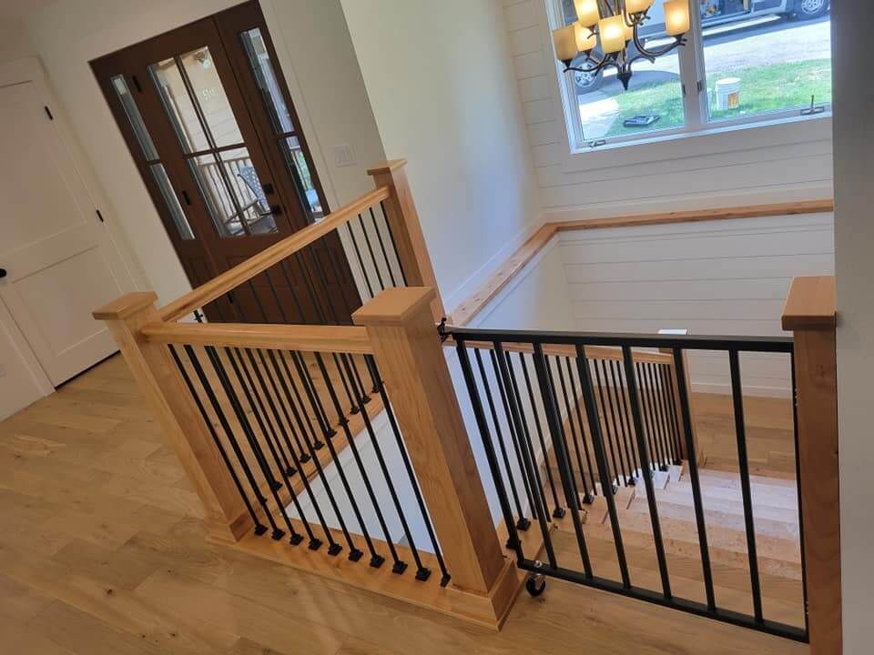 A wooden staircase with a metal railing in a house.