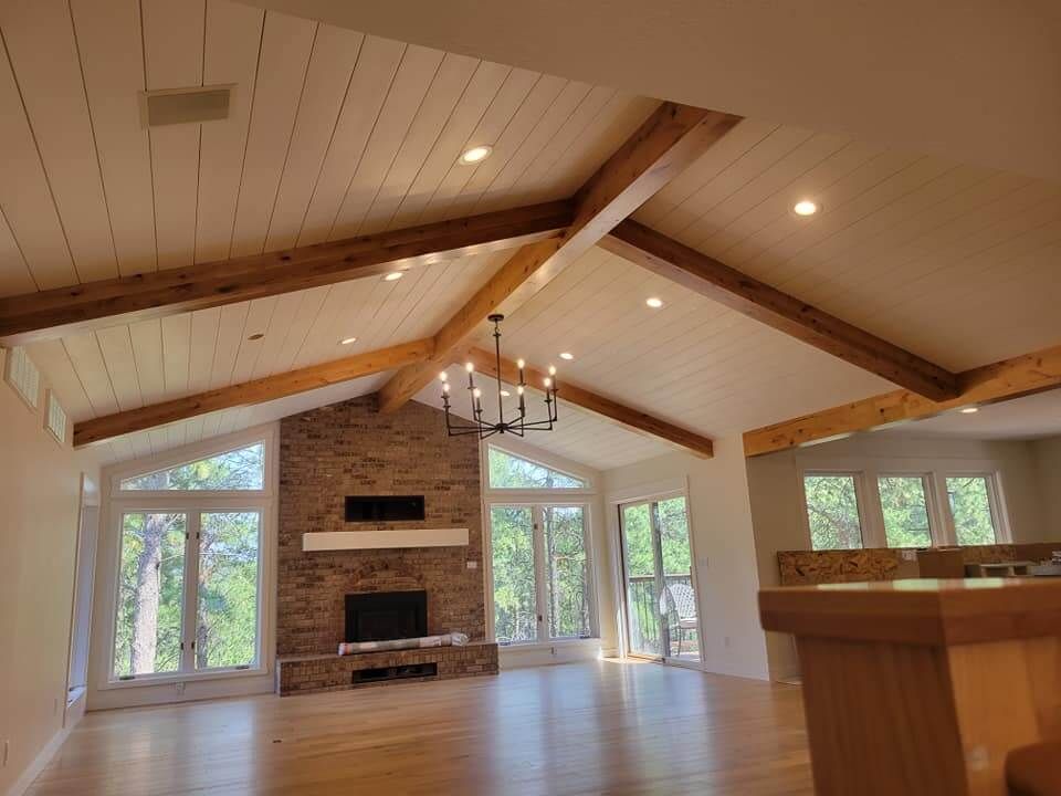 A living room with a vaulted ceiling and a fireplace