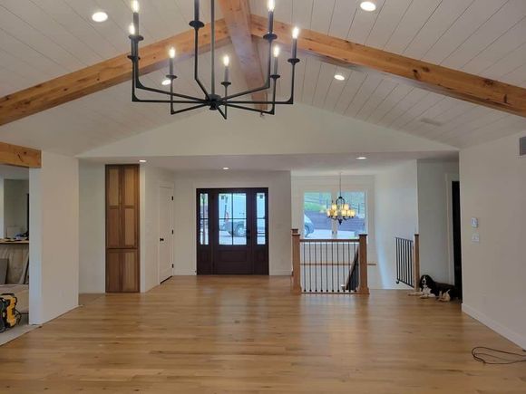 An empty room with a chandelier hanging from the ceiling