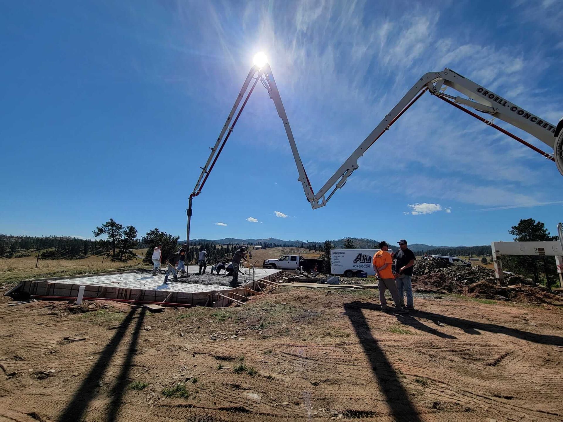 A concrete pump is being used to pour concrete on a construction site.