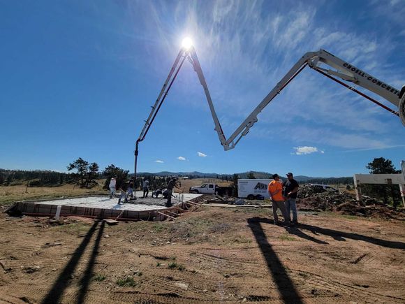 A concrete pump is being used to pour concrete on a construction site.