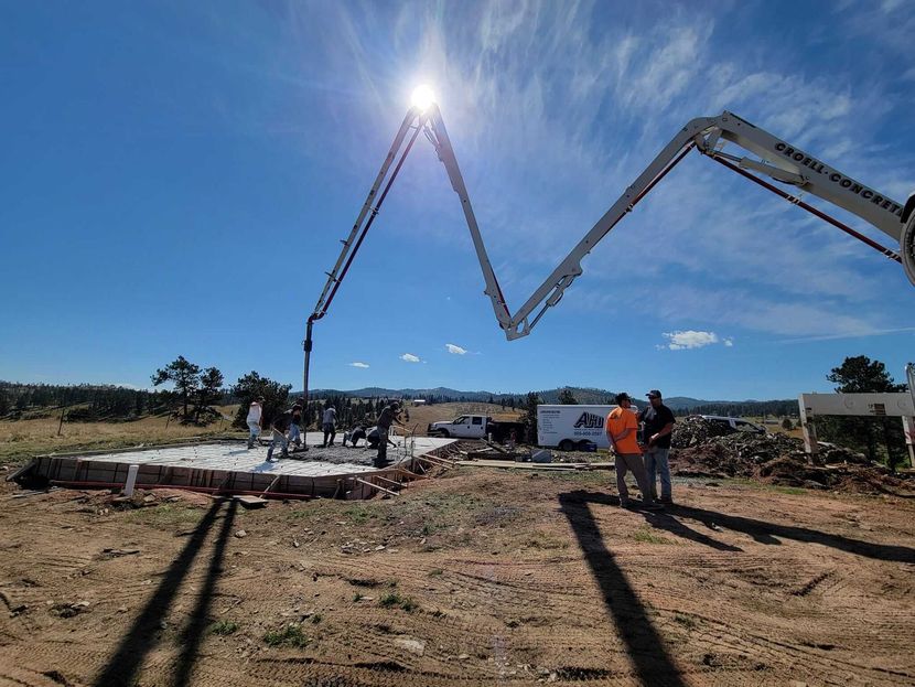 A concrete pump is being used to pour concrete on a construction site.