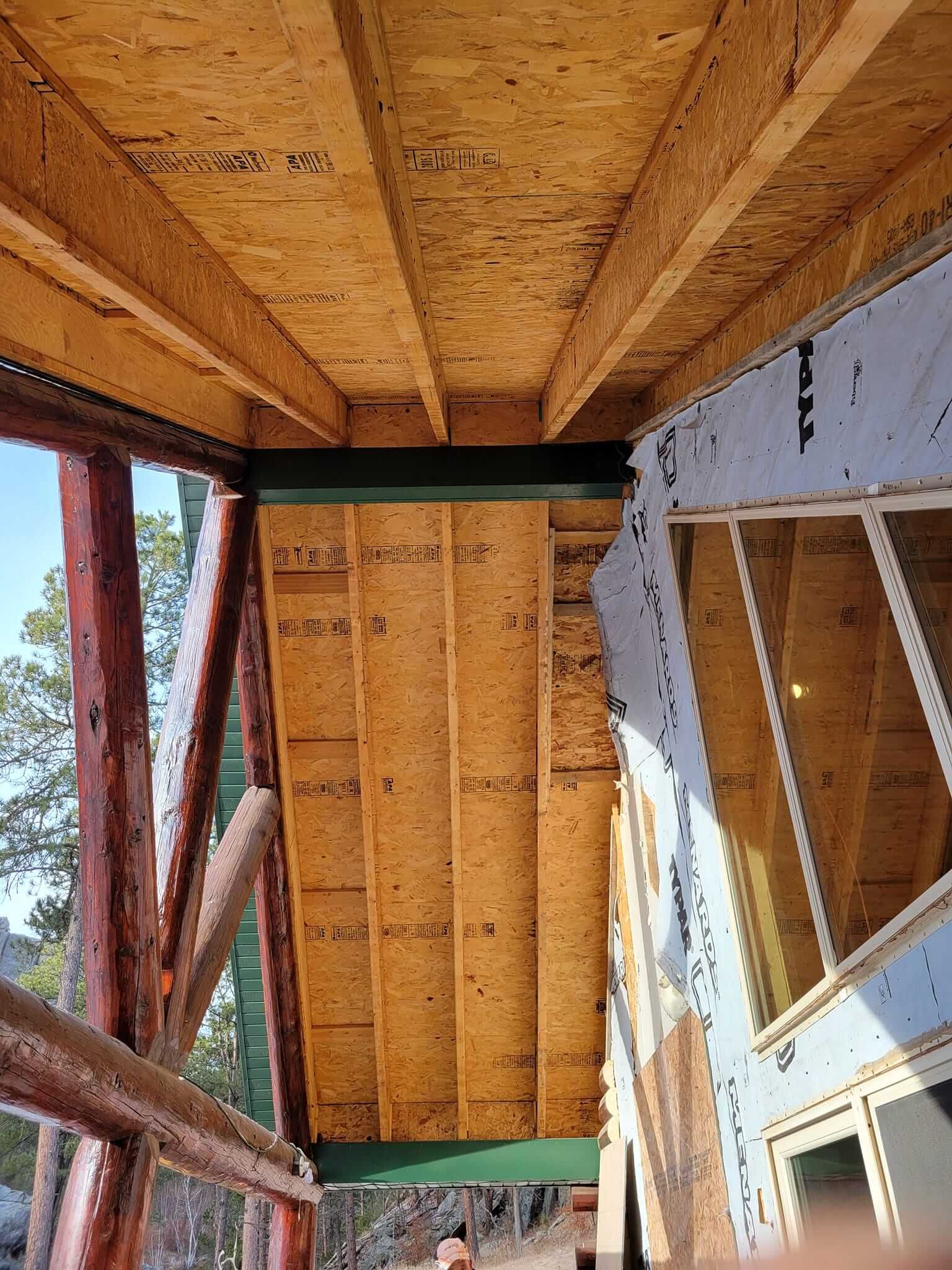 A wooden deck is being built on the side of a house.