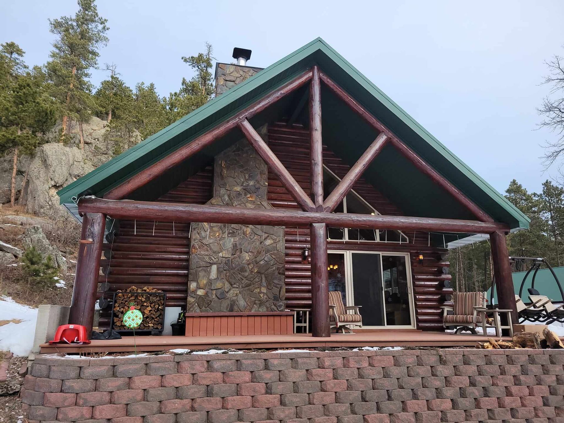 A log cabin with a green roof and a fireplace