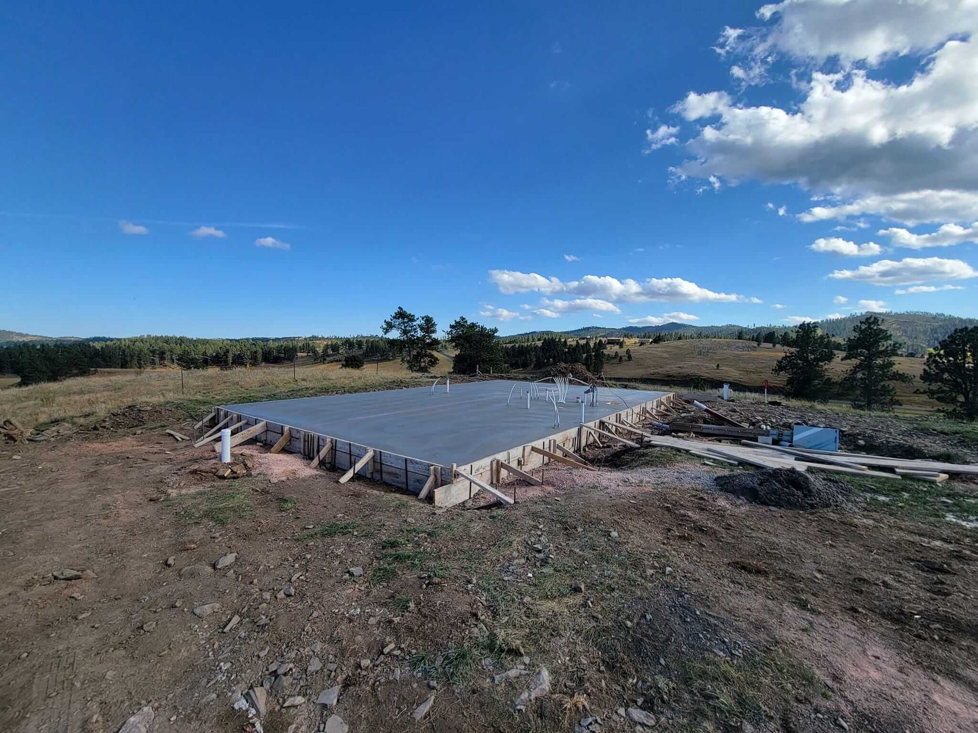 A large concrete slab is sitting on top of a dirt field.