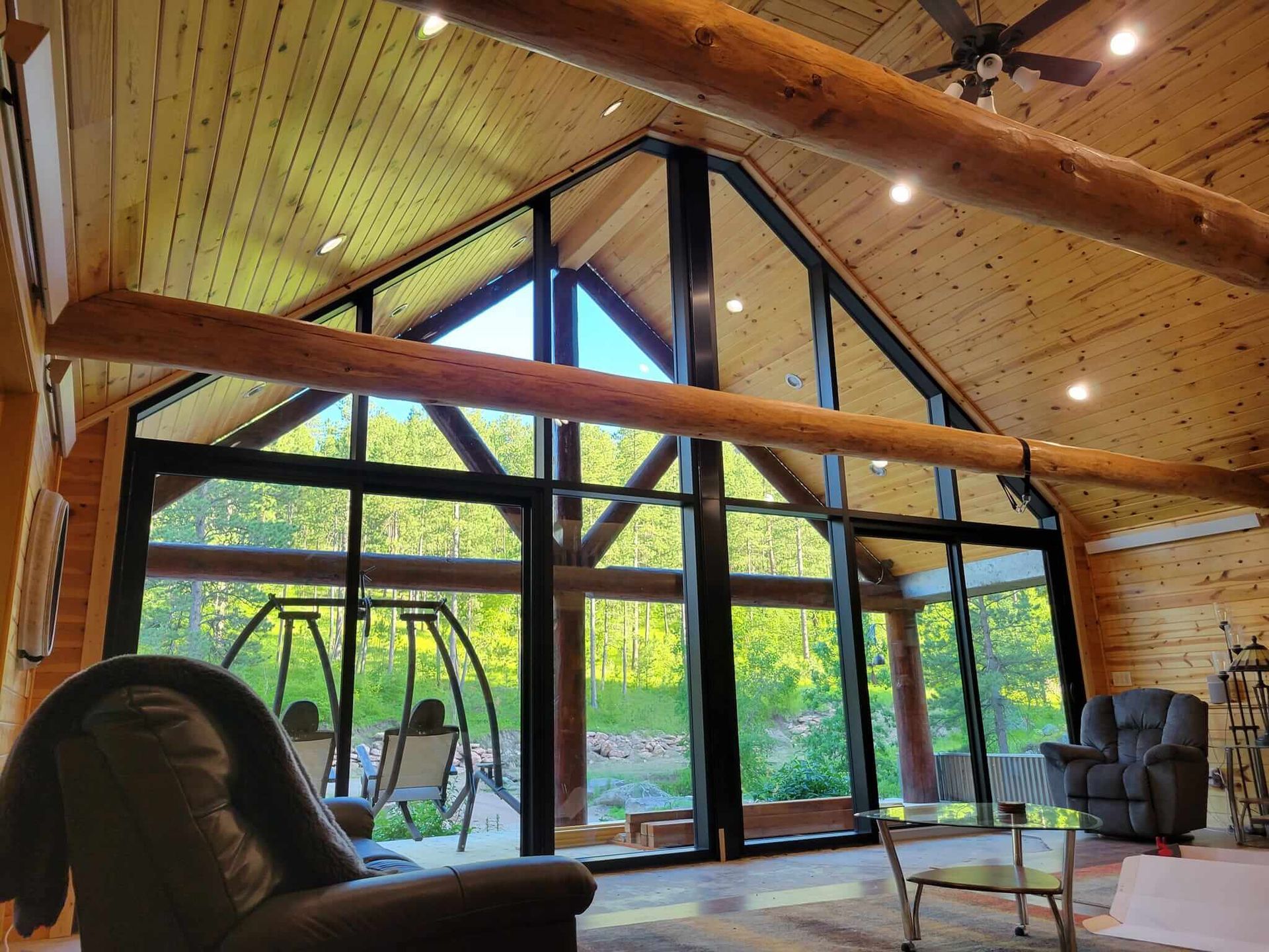 A living room with a lot of windows and a ceiling fan