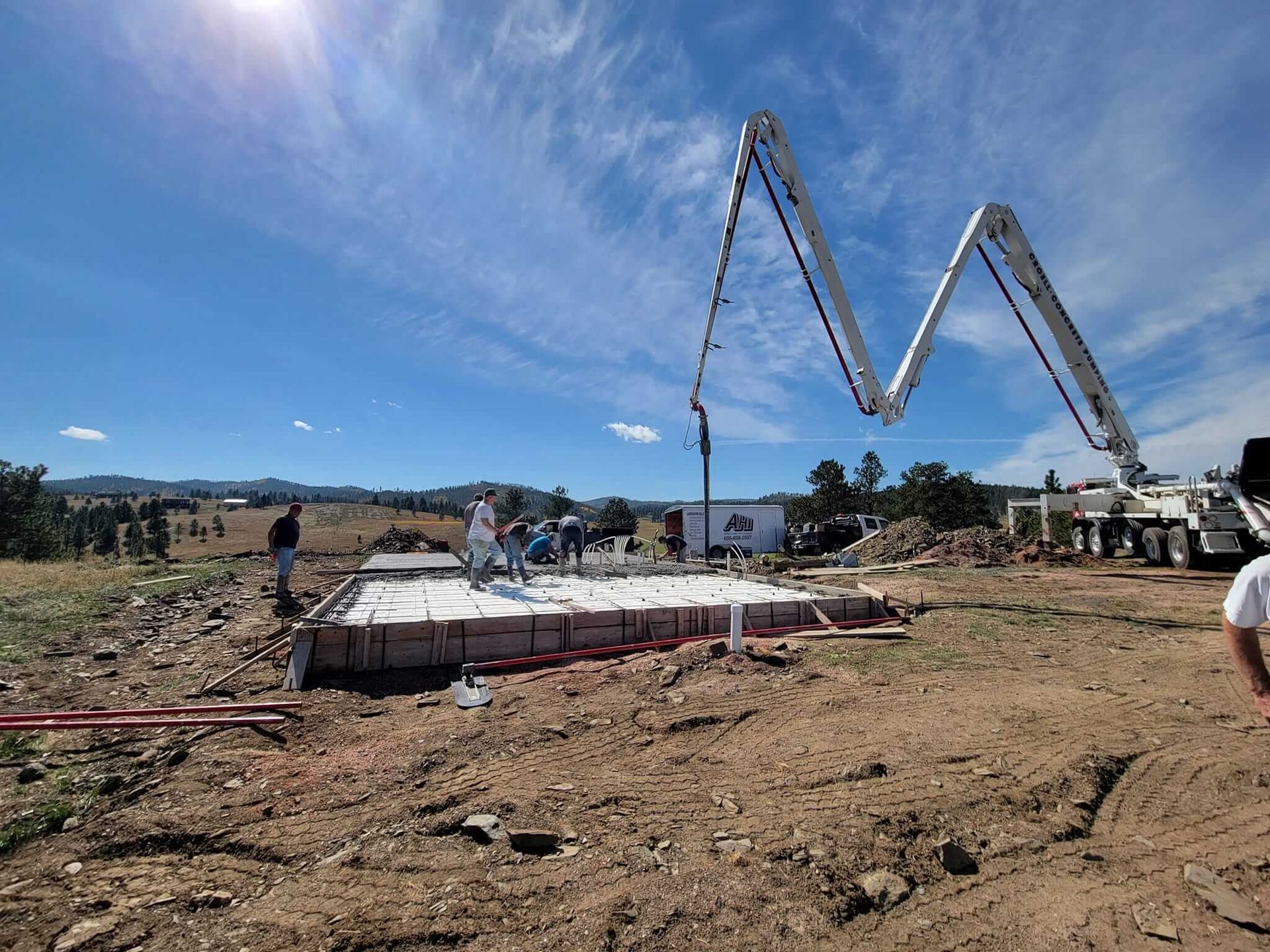 A concrete pump is being used to pour concrete on a construction site.
