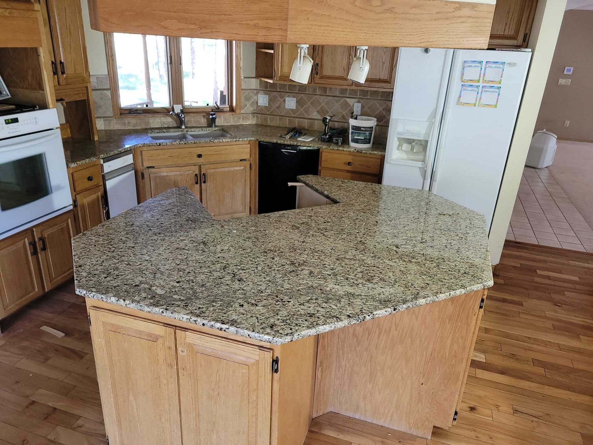 A kitchen with granite counter tops and wooden cabinets