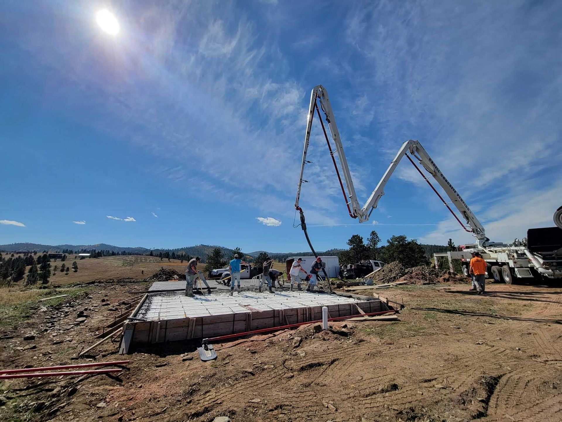 A concrete pump is being used to pour concrete on a construction site.