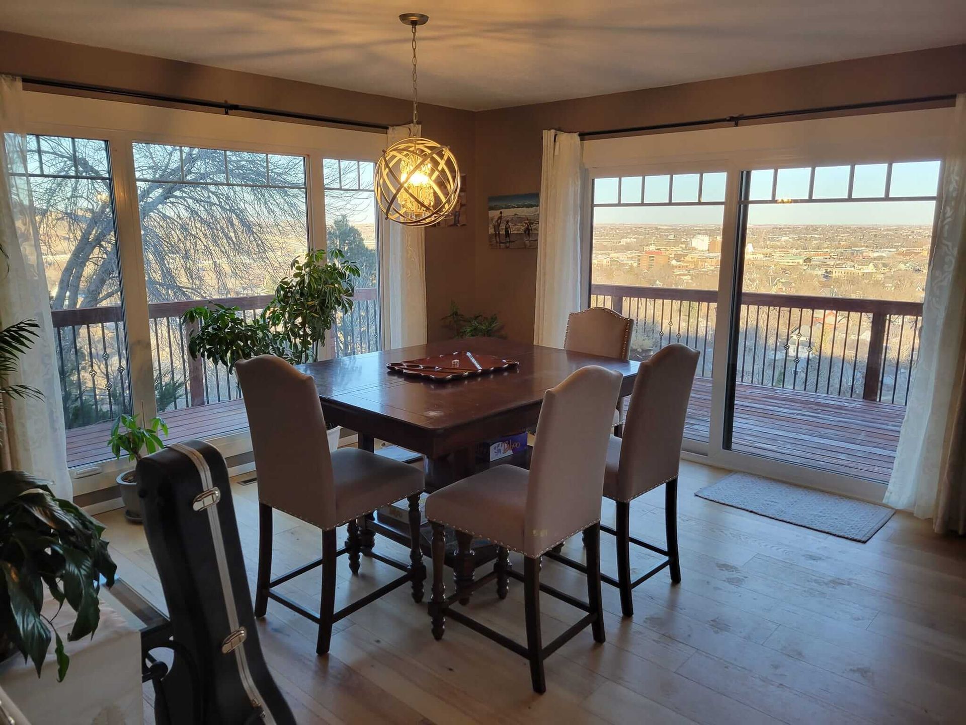 A dining room with a table and chairs and a view of a city.