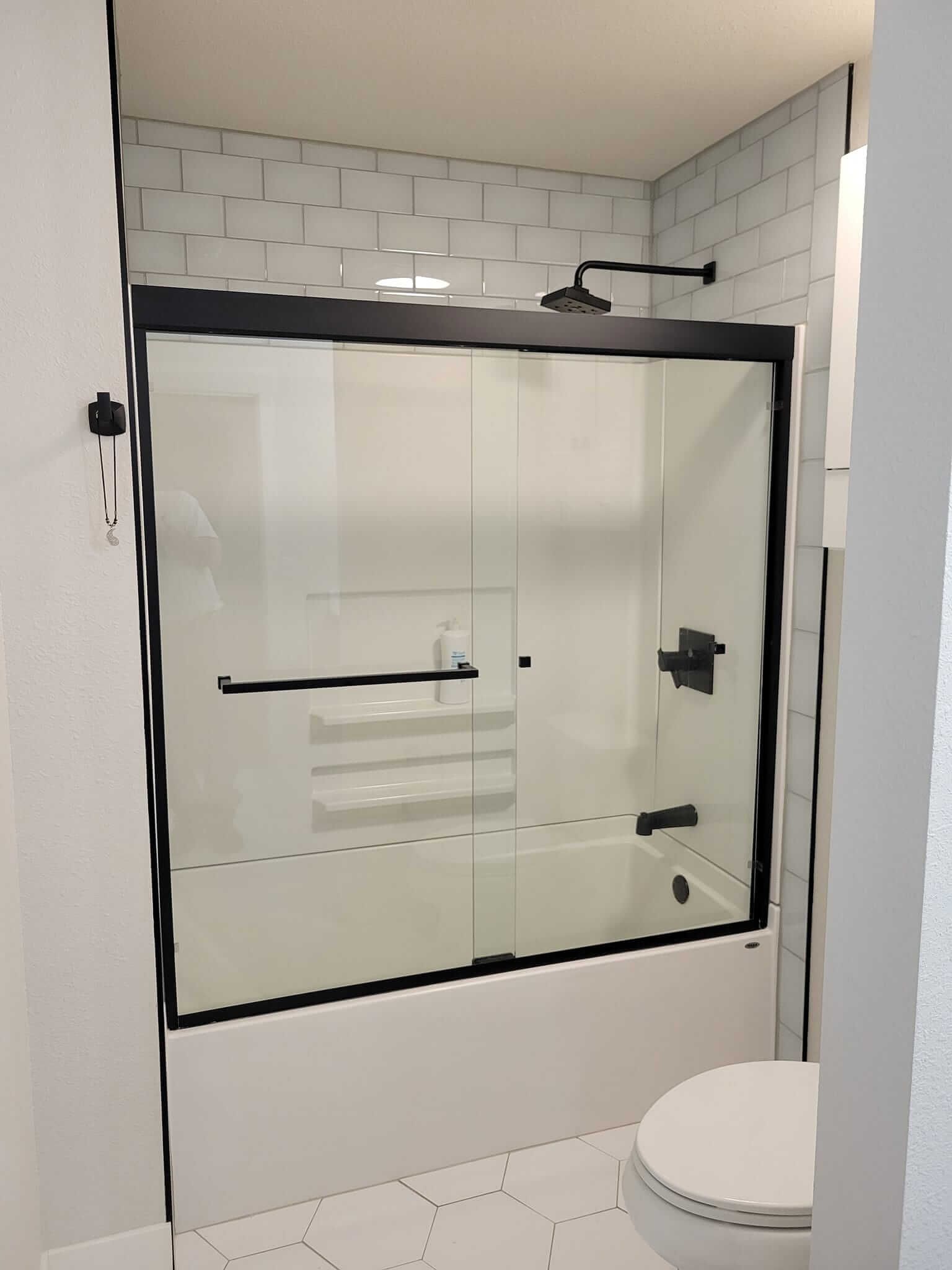 A bathroom with a sliding glass shower door and a bathtub