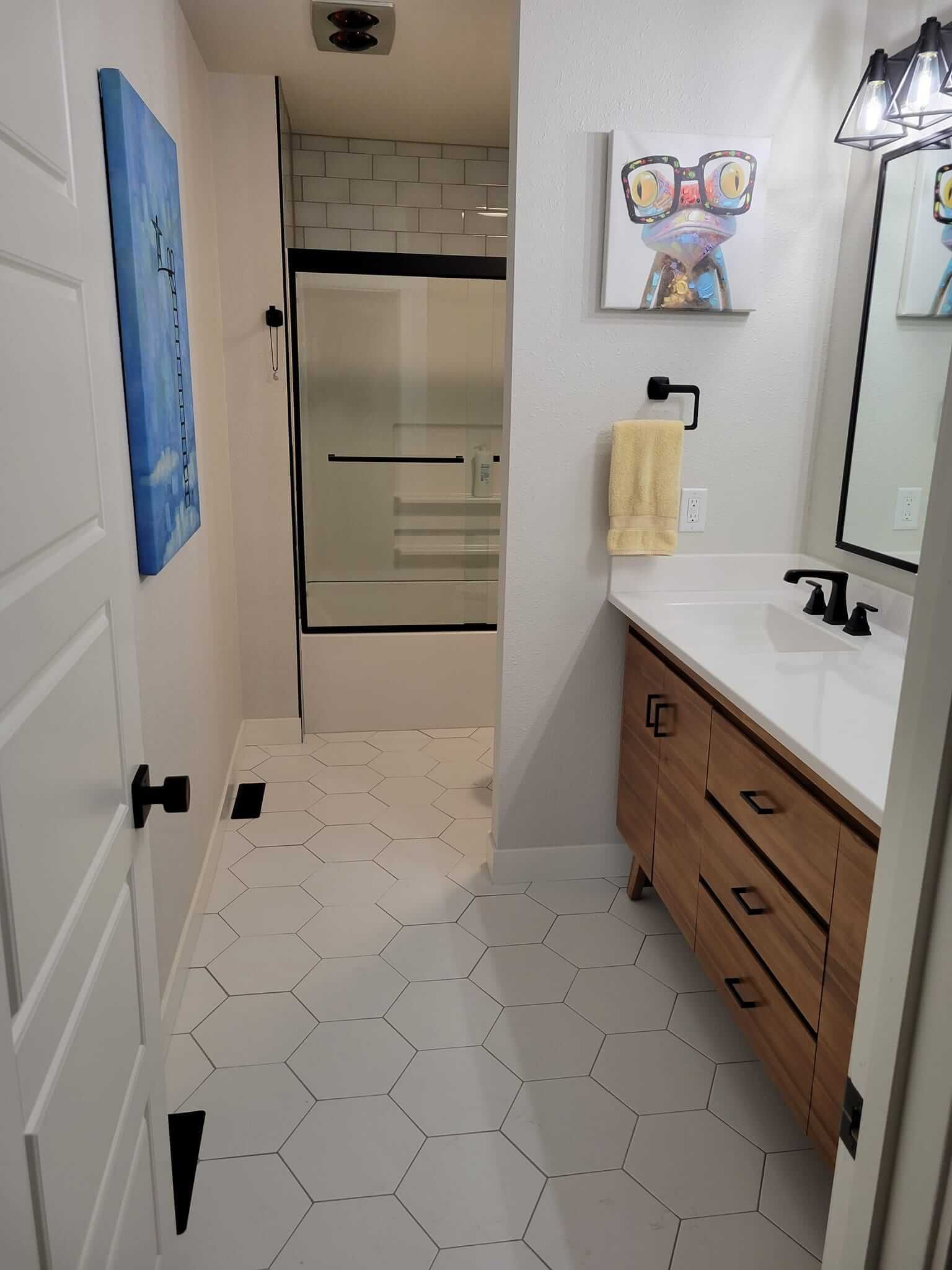 A bathroom with a sink , mirror and shower.
