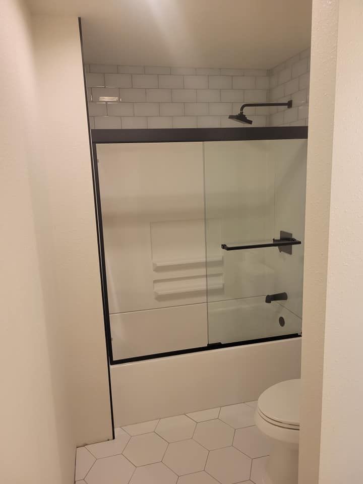 A bathroom with a bathtub , toilet and shower.