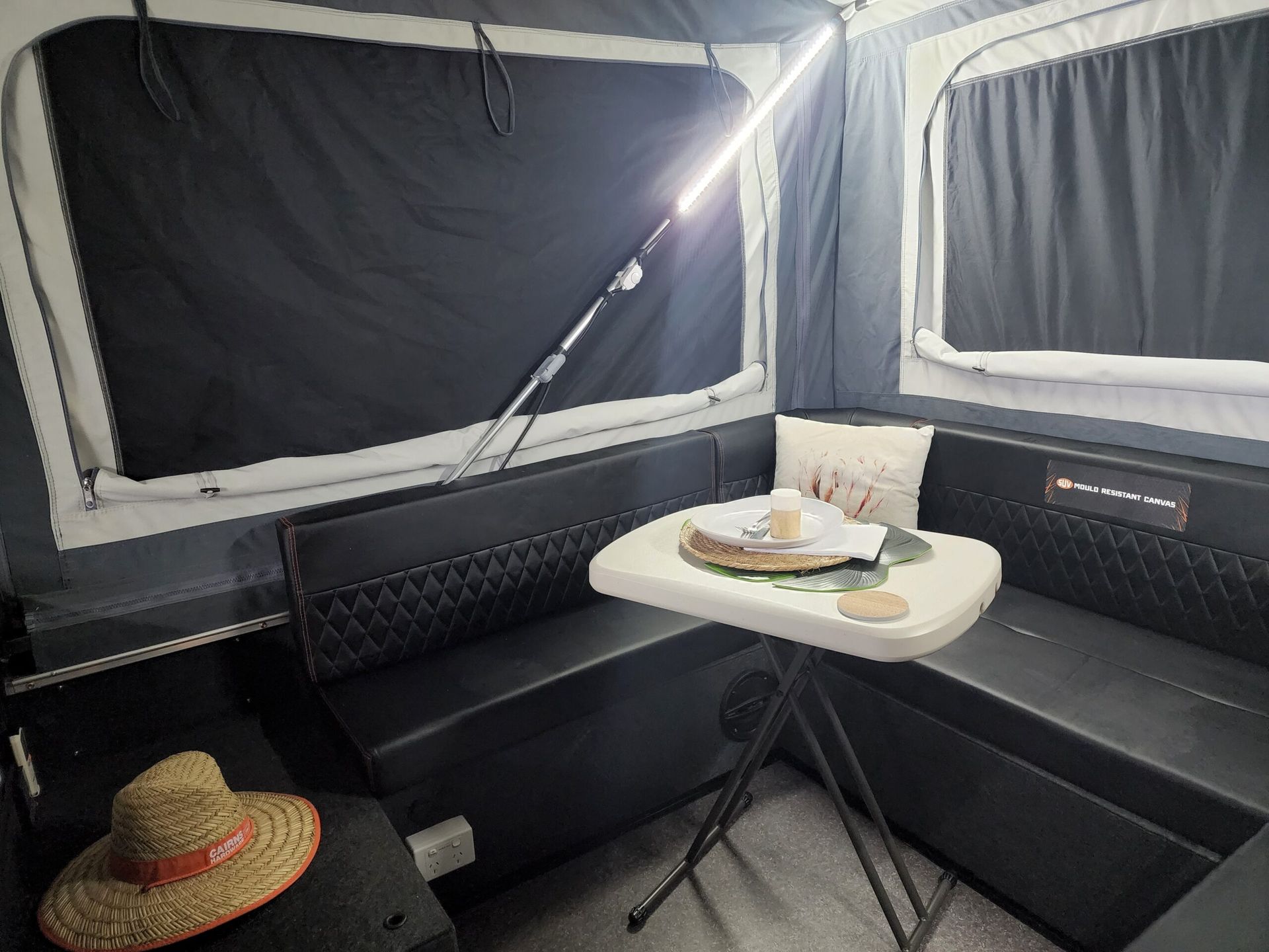A straw hat is sitting on a table in a camper.