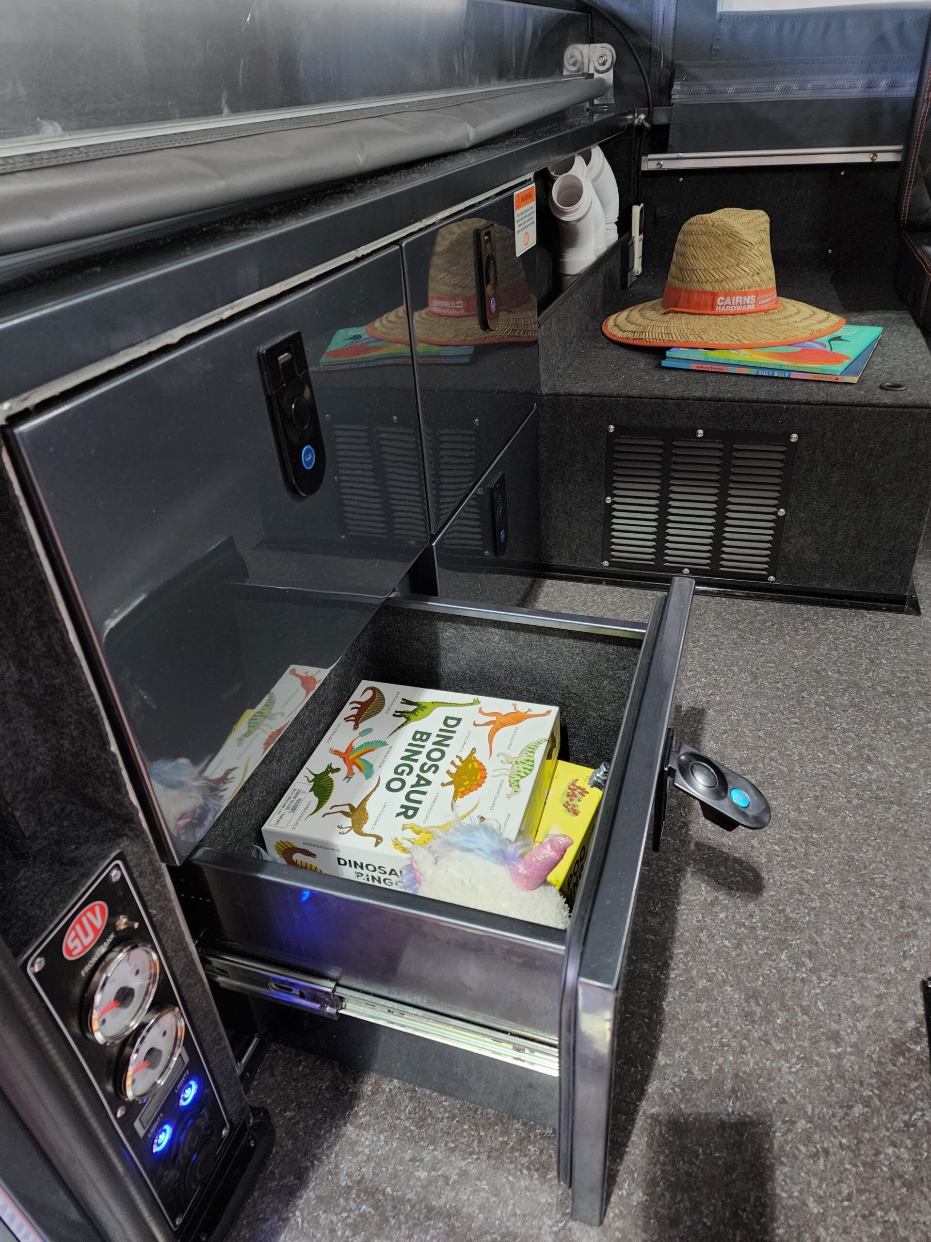 A drawer in a refrigerator filled with boxes and a hat.