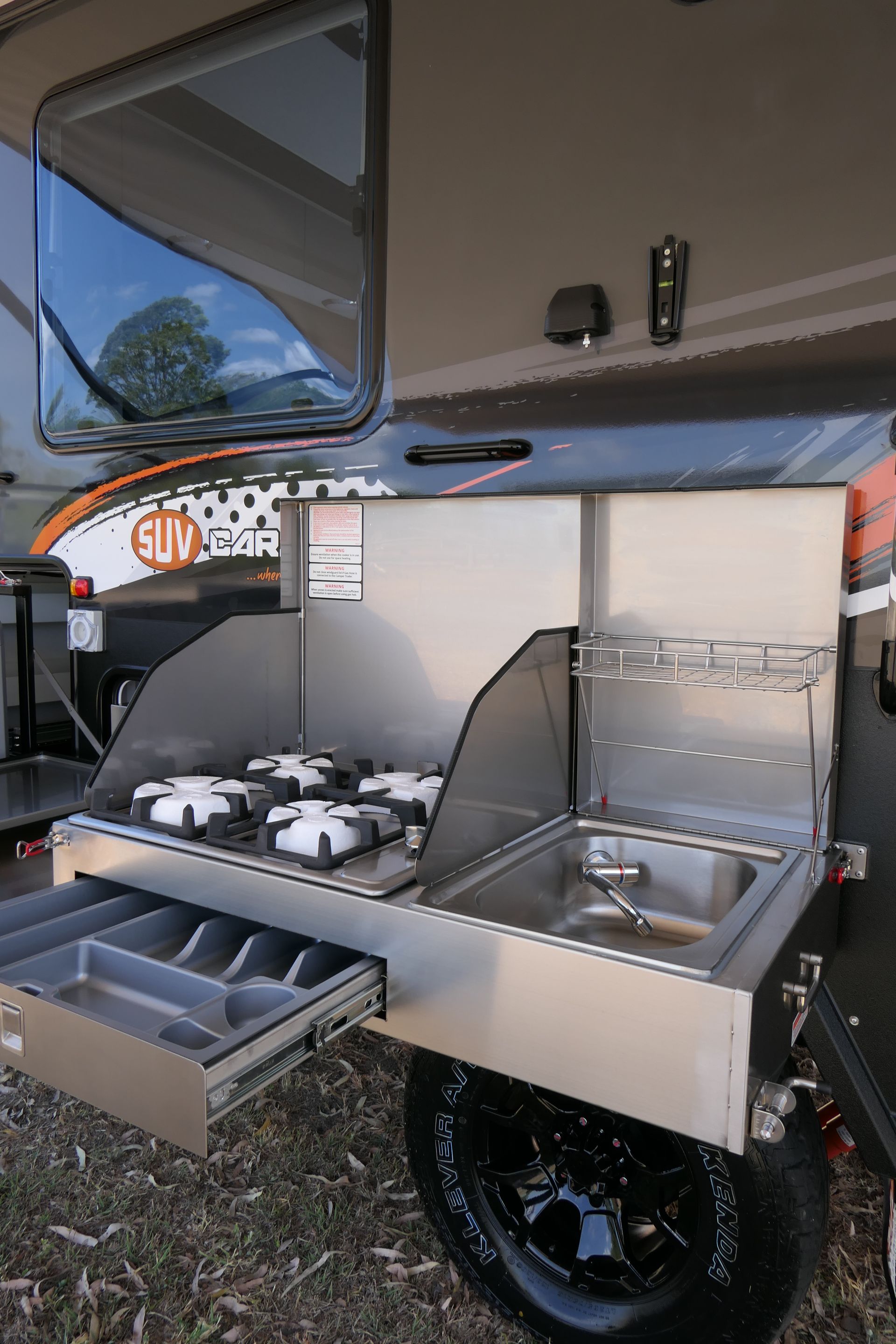 A trailer with a stove and sink attached to it.