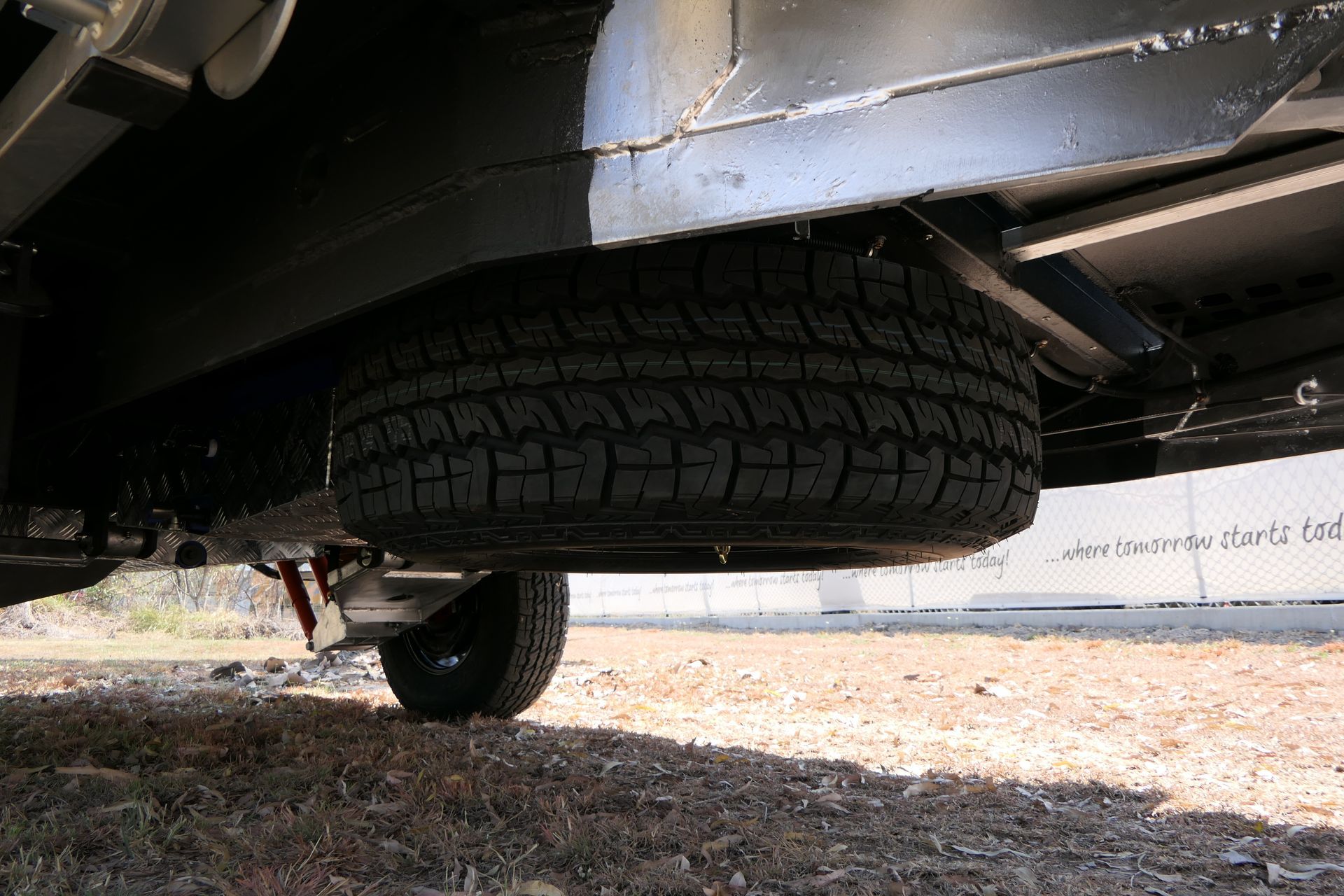 A car with a spare tire underneath it.
