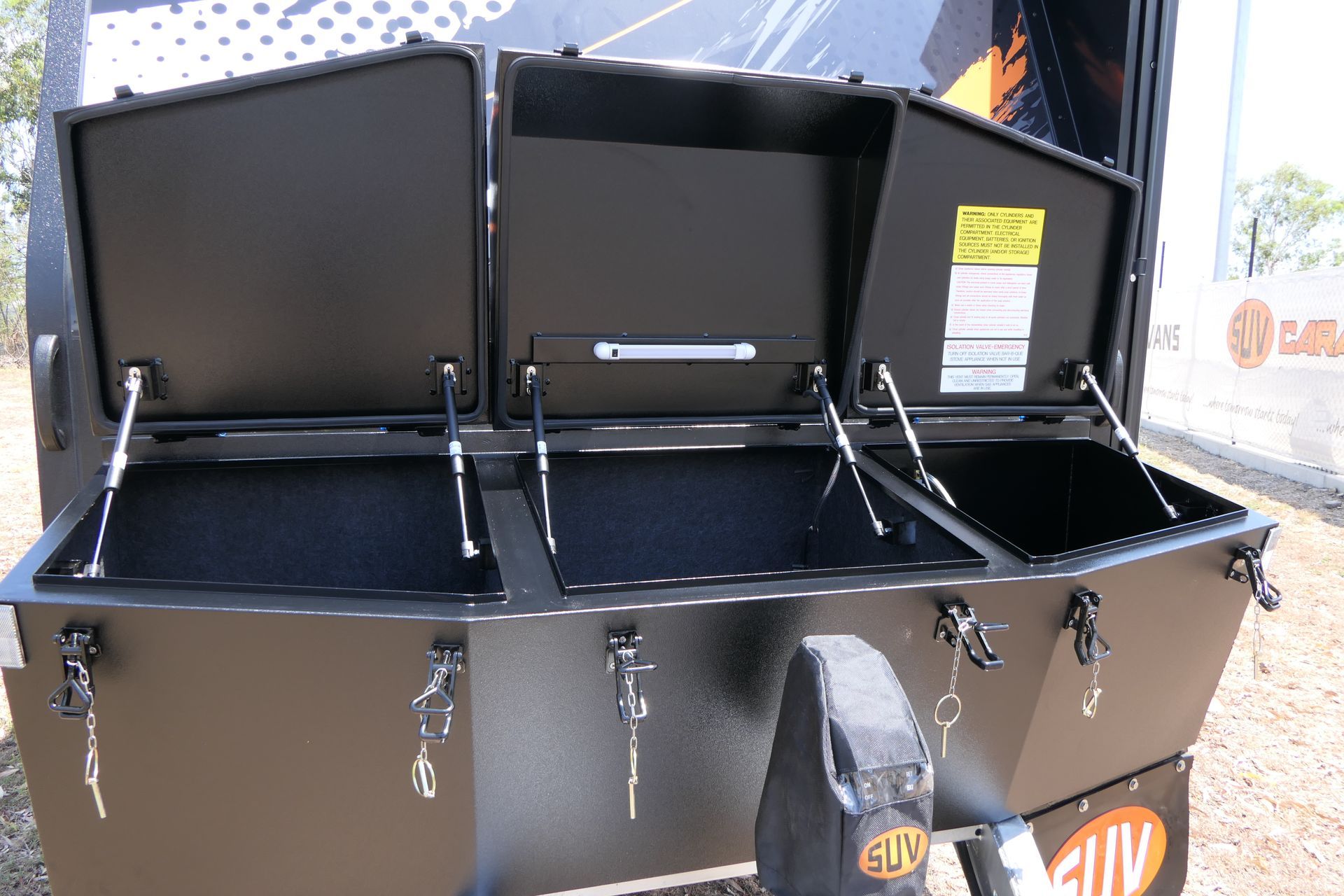 A trailer with the lids open and the word suv on the side